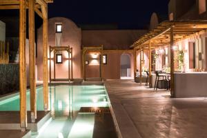 a pool in a house at night with lights at Terra Nera Suites in Perivolos
