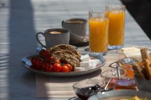 a table with a plate of food and orange juice at Terra Nera Suites in Perivolos