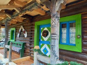 BrebにあるCasa Moroșenilor - Brebの緑のドアと窓が備わるログキャビン