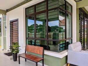 sala de estar con banco y ventana en Syifa Homestay Melaka, en Melaka