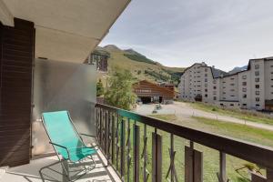 niebieskim krzesłem na balkonie z widokiem w obiekcie Vacancéole - Résidence Lauvitel w mieście Les Deux Alpes