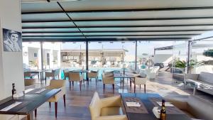 a restaurant with tables and chairs and a view of the ocean at Mövenpick Hotel Casablanca in Casablanca