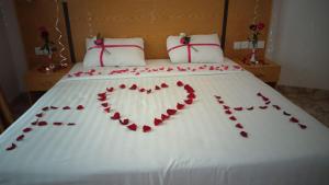 Una cama con un corazón hecho de rosas rojas en Al Reef Hotel, en Mascate