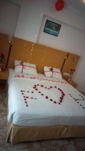 a bedroom with a bed with red hearts on it at Al Reef Hotel in Muscat