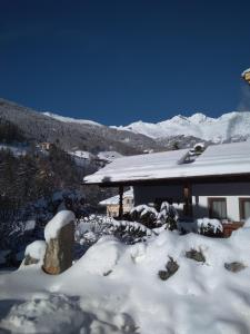 uma casa coberta de neve com montanhas ao fundo em "Michls Hoamat" am Fuße der "stillen Seite" in Sölden em Sölden