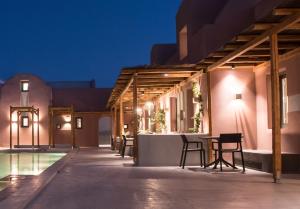 an outdoor patio with a table and chairs at night at Terra Nera Suites in Perivolos