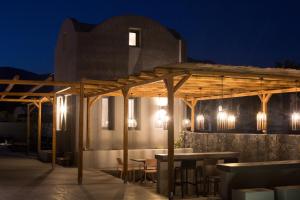 a pavilion with a table and chairs at night at Terra Nera Suites in Perivolos