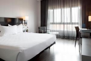 Habitación de hotel con cama grande y ventana en Porcel Torneo, en Sevilla