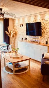 a living room with a table and a tv on a wall at Chez Alphonse : T3 cosy et rénové - proche du port in Vannes