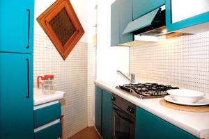 a kitchen with blue cabinets and a stove top oven at Villa Adria in Lignano Sabbiadoro