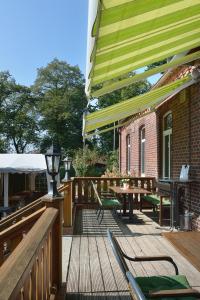 eine Holzterrasse mit einem Tisch und Stühlen darauf in der Unterkunft Land-gut-Hotel Allerhof in Frankenfeld