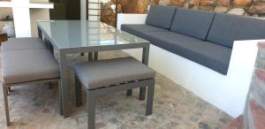 a table and chairs with a glass table and a couch at Villa Vista in Mossel Bay