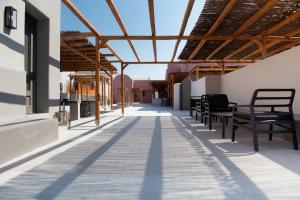 a patio with benches and awnings on a building at Terra Nera Suites in Perivolos
