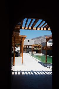 a view of a swimming pool from an archway at Terra Nera Suites in Perivolos