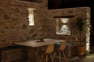 eine Steinmauer mit einem Tisch und 2 Stühlen in der Unterkunft HH Bluewater in Logaras + 47 Fotos