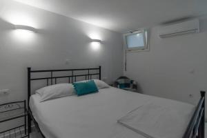 ein Schlafzimmer mit einem großen weißen Bett mit zwei Lampen in der Unterkunft HH Bluewater in Logaras