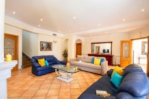 salon z niebieskimi kanapami i stołem w obiekcie Villa Samoa by Algarve Vacation w Albufeirze