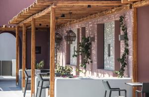 un comedor con mesas y sillas y una pared rosa en Terra Nera Suites en Perivolos