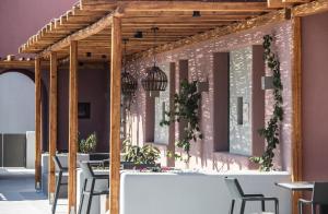 a dining room with tables and chairs and a pink wall at Terra Nera Suites in Perivolos