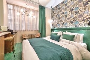 Un dormitorio con una cama verde y blanca y un escritorio en Hotel 33 Marbeuf, en París 61 fotos más