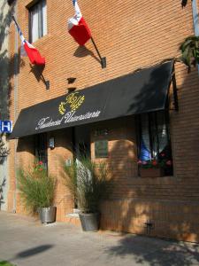 un restaurante con toldo negro en un edificio de ladrillo en Residencial Universitaria en Santiago