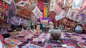 格雷梅的住宿－奈薩洞穴酒店，一间布满色彩缤纷地毯的房间