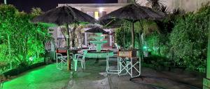un patio con mesas, sillas y sombrillas en San Remo Resort Hotel en Santa Teresita