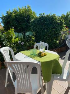 una mesa blanca con un mantel verde. en Guest House AltoNível, en Viana do Castelo