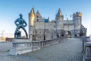 a statue of a man in front of a castle at Panoramic Antwerpen Centrum in Antwerp