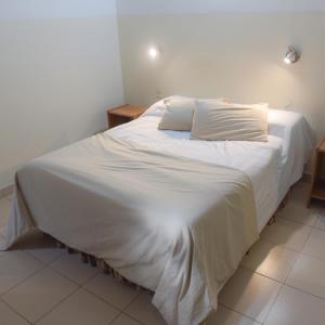 Una cama blanca con dos almohadas encima. en Hospedaje San Lorenzo en Corrientes