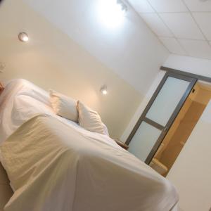 uma cama branca num quarto com uma janela em Hospedaje San Lorenzo em Corrientes