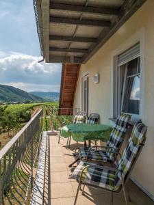 a patio with a table and chairs on a balcony at Ferienweingut Winnebeck in Köwerich