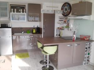 a kitchen with a counter and a clock on the wall at APPART MER CALME ET ENSOLEILLEE in Le Grau-du-Roi