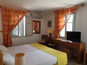 um quarto com uma cama, uma secretária e uma janela em Villa Eleni em Vathi