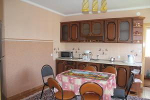 a kitchen with a table with chairs and a counter top at Котедж Любов in Solochyn