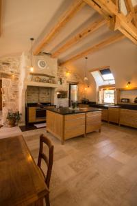 a large kitchen with wooden cabinets and a table at Gîte de France 71 G 2005 labellisé 3 épis - Loft grand volume dans corps de ferme rénovée ANTULLY - MAYMARD Yannick in Antully