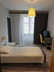 - une chambre avec un grand lit et une fenêtre dans l'établissement Hotel Fleur-de-Lys, à La Chaux-de-Fonds