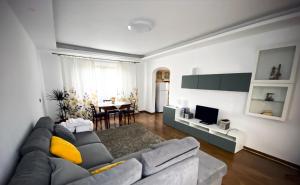 a living room with a couch and a dining room at Casuta Fulgu - sa te simti ca acasa! in Borşa