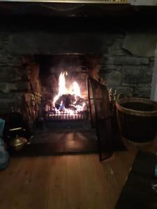a brick fireplace with a fire in it at The Speyside Hotel and Restaurant in Grantown on Spey