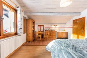 a bedroom with a bed and a kitchen with a table at Chalet Bluebell in Les Gets