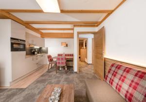 a kitchen and a living room with a table at Apartments & Garni Alpenrose in Obertauern
