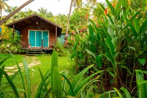 a small cabin in the middle of a garden at Montego Bay Beach Village - Morjim in Morjim