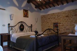 1 dormitorio con cama y pared de ladrillo en Azienda Agrituristica Colle San Giorgio, en Castiglione Messer Raimondo