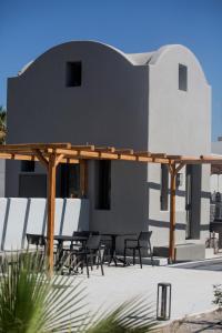 a group of chairs and tables under a pergola at Terra Nera Suites in Perivolos