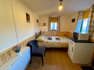 a small bedroom with a bed and a microwave at Per Ardua Shepherds Hut in Fort William