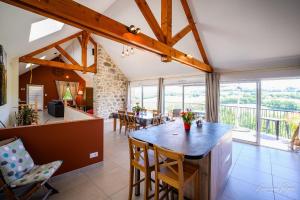 a kitchen and living room with a table and chairs at La Fournial in Lunac