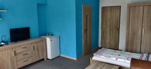 a bedroom with blue walls and a small refrigerator at Ubytování u Kováře in Ústí nad Labem