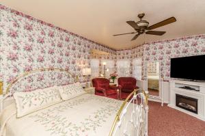 1 dormitorio con 1 cama con papel pintado de flores rosas en Apples Bed and Breakfast Inn en Big Bear Lake