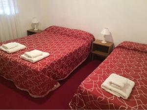 twee bedden in een hotelkamer met handdoeken erop bij Hotel Ser-Mar in San Bernardo +8 foto's