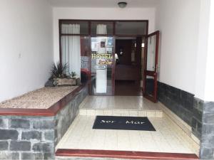 een deur naar een hotel met een bord op de vloer bij Hotel Ser-Mar in San Bernardo